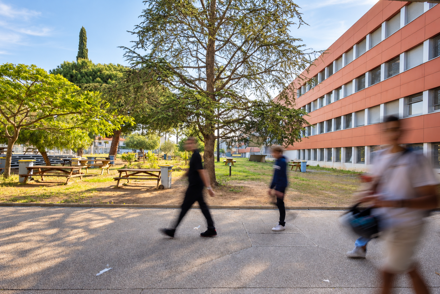 Élèves traversant les espaces extérieurs arborés du lycée Antoine de Saint-Exupéry à Saint-Raphaël