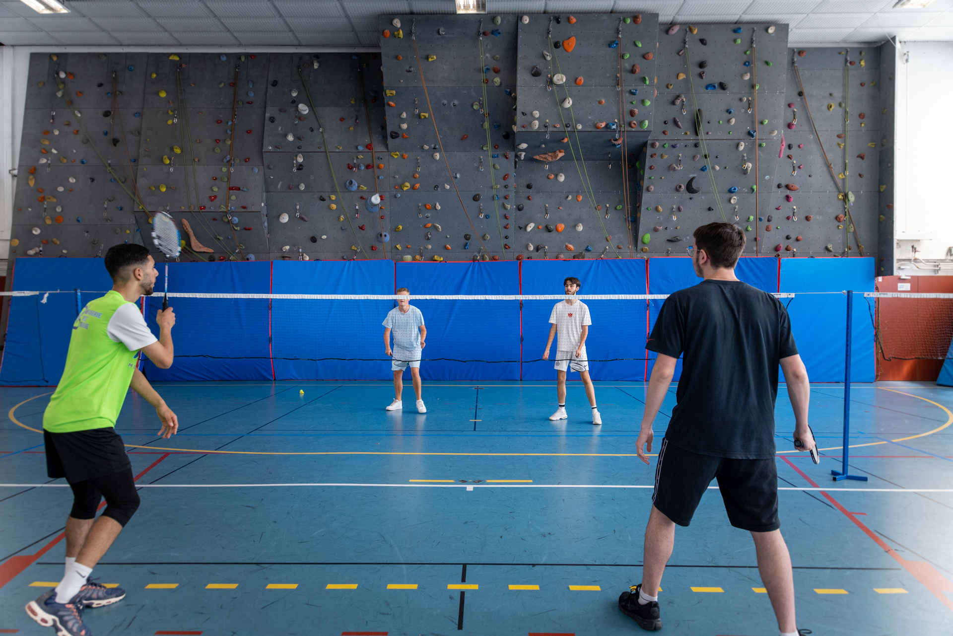Des étudiants jouent au badminton dans le gymnase du lycée